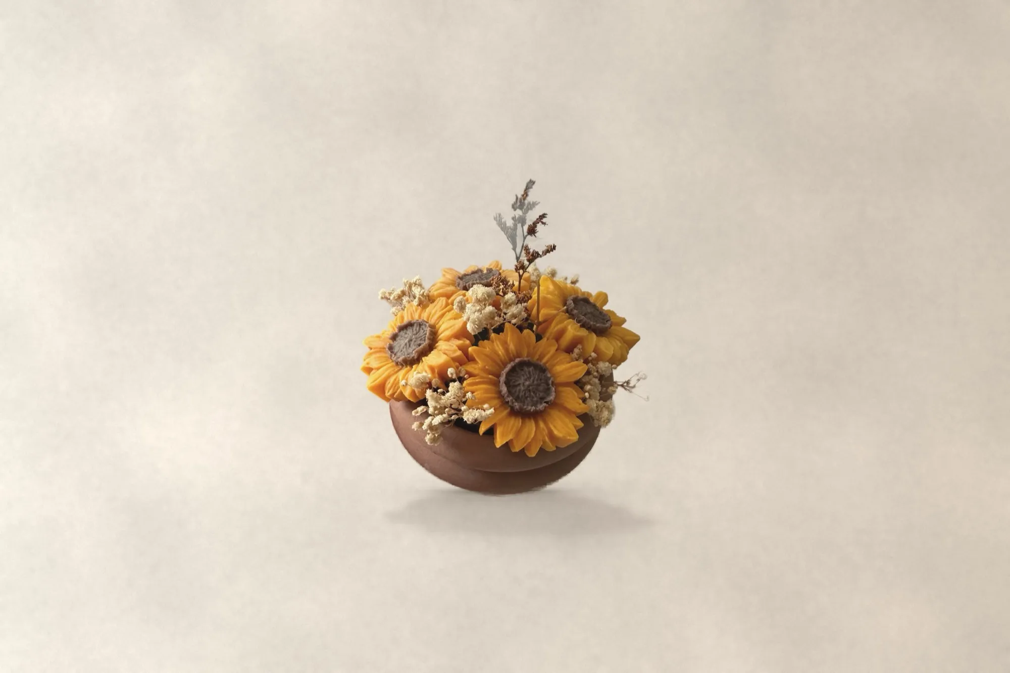 A bouquet of wax sunflowers in a terracotta pot