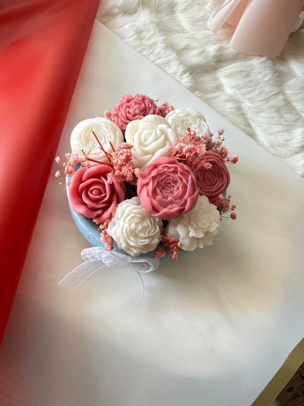 The bouquet wrapped for gifting against red paper